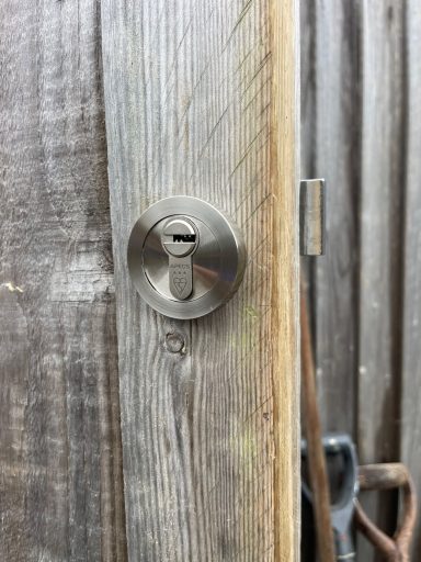 Close-up of a keyhole in a wooden door.